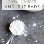 closeup of tablespoon of cornstarch next to a small bowl with title text overlay